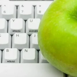 A green apple on a keyboard